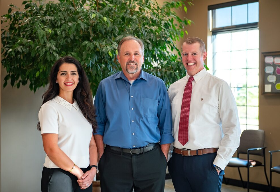 Dental team members at Westermeier Martin Dental Care in East Amherst, featuring Dr. Andrew Burke, in a welcoming office environment with greenery and natural light.