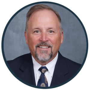 John N. Athans, DDS, smiling in a professional suit, representing the dental team at Westermeier Martin Dental Care, focused on comprehensive dental services and patient care.